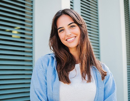 Woman with white teeth smiling while standing outside