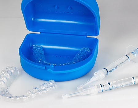teeth whitening trays with syringes of whitening gel next to them