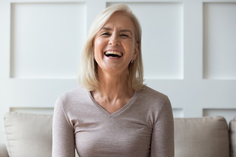 an older woman laughing while at home